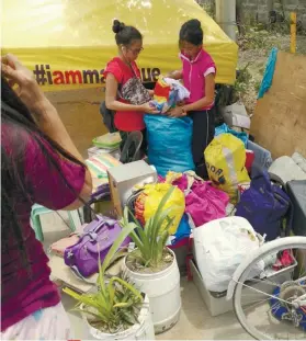  ?? ALAN TANGCAWAN SUNSTAR FOTO / ?? REMAINS OF THE DAY. Survivors gather what was left of their belongings after fire destroyed their house in Barangay Subangdaku.