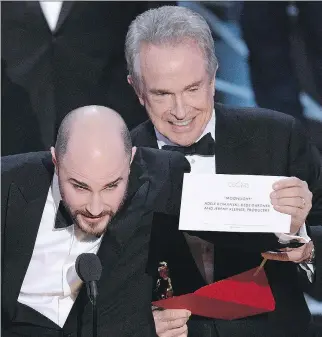  ?? CHRIS PIZZELLO/INVISION/THE ASSOCIATED PRESS ?? Jordan Horowitz, producer of La La Land, shows the envelope revealing Moonlight as the true winner of best picture at the Oscars on Sunday. Presenter Warren Beatty looks on.