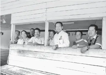  ??  ?? Dennis (fifth right) and Mohammad Razin (fifth right) looking out from the corridor of Sg Babi longhouse.