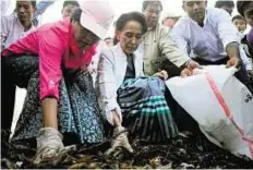  ?? AFP ?? Leading from the front Aung San Suu Kyi (centre) clears garbage with NLD party members and local residents during a clean-up in Kawhmu township, Yangon yesterday.