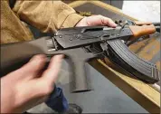  ?? GEORGE FREY / GETTY IMAGES ?? A bump stock is installed on an AK-47 and its movement is demonstrat­ed at Good Guys Gun and Range on Feb. 21 in Orem, Utah.