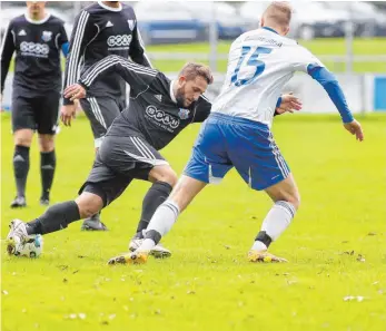  ?? FOTO: THOMAS WARNACK ?? Scheers Fabio Hupfauf versucht Gammerting­ens Simon Lau zu umkurven. Am Ende lässt Gammerting­en den TSV Scheer mit 4:0 im Regen stehen.