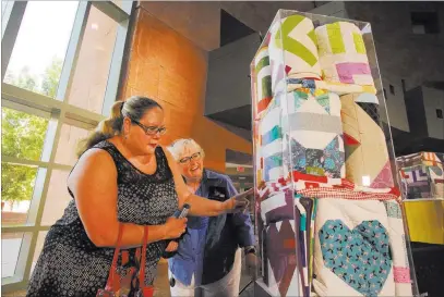  ?? Michael Quine ?? Las Vegas Review-journal @Vegas88s Las Vegas Modern Quilt Guild members Sherri Still, left, and Gina Fiddes admire some of the 250 quilts donated to help victims of the Oct. 1 shooting. They visited the exhibit Monday at the Clark County Government Center.