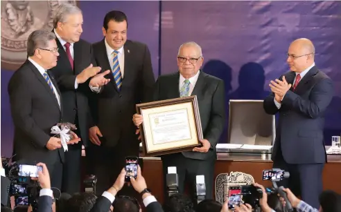  ??  ?? Don Antonio Gutiérrez recibió la presea de manos del rector Salvador Hernández y del secretario de Gobierno José María Fraustro por su obra y compromiso social en favor de los jóvenes.