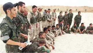  ??  ?? Members of the Syrian Democratic Forces gather after a training session at a firing range in northern Syria in this file photo. (AFP)