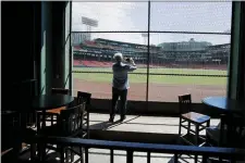  ?? ELISE AMENDOLA — THE ASSOCIATED PRESS ?? A reporter photograph­s the view of the baseball field at Fenway Park from the Bleacher Bar in Boston.