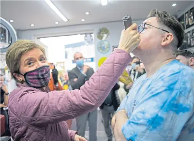  ?? Picture Wattie Cheung ?? Nicola Sturgeon shaves barber Tony Cairney’s beard on visit to East Kilbride