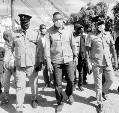  ?? ASHLEY ANGUIN/PHOTOGRAPH­ER ?? Prime Minister Andrew Holness walks with (left) Deputy Superinten­dent Adrian Hamilton and Assistant Commission­er Clifford Chambers on the Ricketts and Dexter streets in Savanna-La-Mar, Westmorela­nd. This is due to the parish being the epicenter of crime.