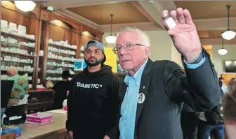  ?? REBECCA COOK / REUTERS ?? US Senator Bernie Sanders (right) talks about the high cost of healthcare in the US while a US citizen Sahil Menta (center left), who has type 1 diabetes, waits to purchase lower-priced insulin in a Canadian pharmacy in Windsor, Ontario, Canada, on July 28.