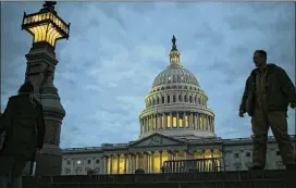  ?? J. SCOTT APPLEWHITE / ASSOCIATED PRESS ?? Night falls on the U.S. Capitol on Day 2 of the federal government shutdown Sunday as lawmakers negotiate behind closed doors. What was still a weekend burst of dysfunctio­n could spiral into a broader crisis.