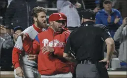  ?? FRANK FRANKLIN II — THE ASSOCIATED PRESS FILE ?? Phillies manager Gabe Kapler, center between Bryce Harper and an umpire in this entertaini­ng snapshot from the season, has successful­ly stemmed the tide of management blowback during this sinking season of too many poor performanc­es and too much bad injury luck. The future remains speculativ­e.