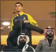  ?? Amr Nabil / Associated Press ?? Cristiano Ronaldo, a new member of Al Nassr soccer club, puts on his jacket as he attends his team’s match on Friday in Riyadh, Saudi Arabia.