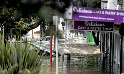  ?? PHOTO: LAWRENCE SMITH\FAIRFAX NZ ?? Two cars stranded in the flooding in New Lynn, Auckland, yesterday.