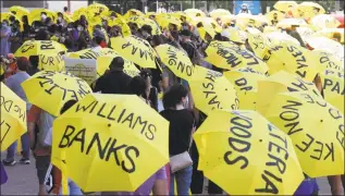  ?? LM Otero / Associated Press ?? People hold yellow umbrellas during a Juneteenth 2020 celebratio­n and protest against police brutality in Dallas on Friday. The umbrellas bear the names of people who have been killed.