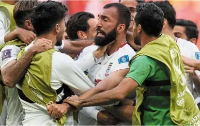  ?? ?? Jaw-dropping: Iran’s rouzbeh Cheshmi (centre) celebrates with teammates after scoring the opening goal during their match against Wales. — AP