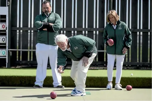  ?? IAIN McGREGOR/STUFF ?? Former All Blacks player and coach Alex Wyllie on the green, watched by team-mates Na Katae and Jenny Anderson.