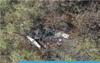  ?? —AFP ?? The tail of the burned fuselage of a small plane that crashed is seen near trees in Guanacaste, Corozalito, Costa Rica.