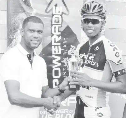  ?? (Orlando Charles photo) ?? Team Coco’s Jamal John receiving his first place trophy from Errol Nelson, Brand Manager of Banks DIH Limited yesterday following the PowerAde 40-mile road race at West Demerara.
