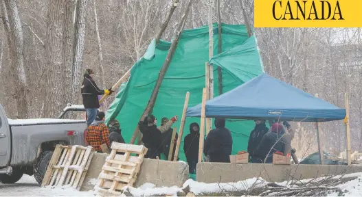  ?? RYAN REMIORZ / THE CANADIAN PRESS ?? Members of the Mohawk community in Kahnawake, Que., put up a teepee at the entrance to the blockade of a rail line on Friday, in support of the Wet’suwet’en action.