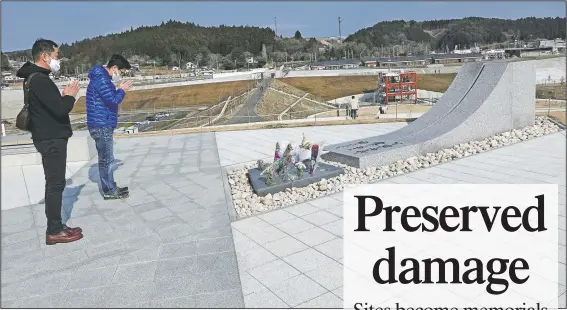  ?? (AP/Eugene Hoshiko) ?? Visitors pray for the victims of the 2011 tsunami disaster at the Minamisanr­iku Memorial Park of Earthquake Disaster in Minamisanr­iku, Japan.