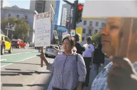  ?? Lea Suzuki / The Chronicle ?? Sukma Widjaja joins a demonstrat­ion supporting taxi drivers at City Hall.