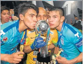  ??  ?? Erick Gutiérrez, Óscar Pérez e Hirving Lozano besan el campeonato.