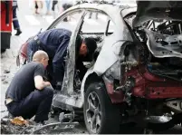  ?? (Valentyn Ogirenko/Reuters) ?? INVESTIGAT­ORS INSPECT a damaged car at the site in central Kiev where journalist Pavel Sheremet was killed by a car bomb yesterday.