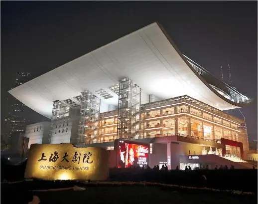  ?? ?? Shanghai Grand Theater looks like a dazzling palace of light and water at night.