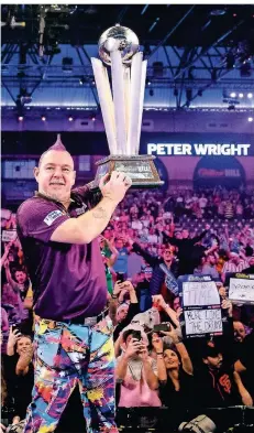  ?? FOTO: STEVEN PASTON/DPA ?? Der Schotte Peter Wright jubelt nach seinem Sieg bei der Darts-WM 2020 und hebt die Sid-Waddell-Trophäe in die Luft.