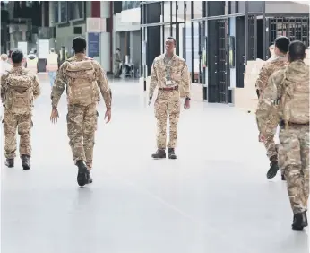  ??  ?? Soldiers and contractor­s at the ExCel centre in London. (Photo by Stefan Rousseau - WPA Pool/Getty Images)