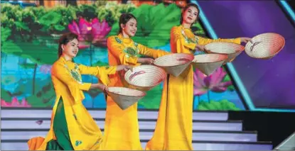  ?? HU CHAO / XINHUA ?? Artists from Vietnam dance with bamboo hats at a cultural event held in China’s Yunnan province on Nov 30.