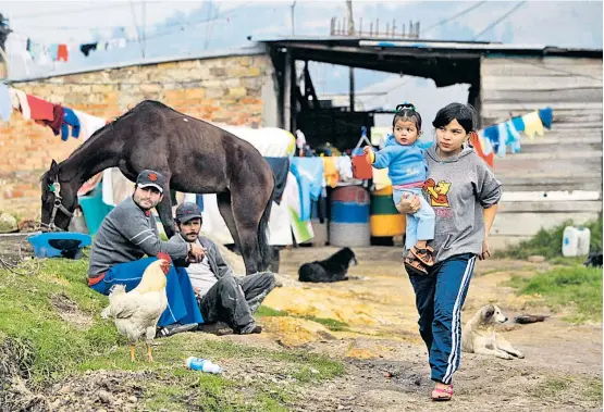  ??  ?? Menschen in einem Lager für Binnenvert­riebene der bewaffnete­n Konflikte nahe der kolumbiani­schen Hauptstadt Bogotá.