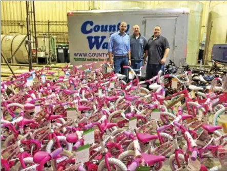  ?? GLENN GRIFFITH - GGRIFFITH@DIGITALFIR­STMEDIA.COM ?? From left, County Waste Clifton Park employees Mark Ceresa, Duane Hromada and John Huggins stand with some of the assembled bikes that were to be donated throughout the Capital Region.