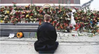  ?? AFPPIX ?? A man pays his respects on Saturday at a makeshift memorial near the site where a truck slammed into a crowd in Stockholm.