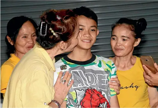  ??  ?? Family greet Duangpetch Promthep, one of the boys rescued from the flooded cave in northern Thailand, as he arrives home in the Mae Sai district, Chiang Rai province, northern Thailand.