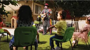  ?? CHRISTINA HOUSE / LOS ANGELES TIMES / TNS ?? Profession­al clown Guilford Adams, performing at a preschool in Glendale, Calif., is having difficulty finding work. When he does, he wears a mask and practices social distancing.