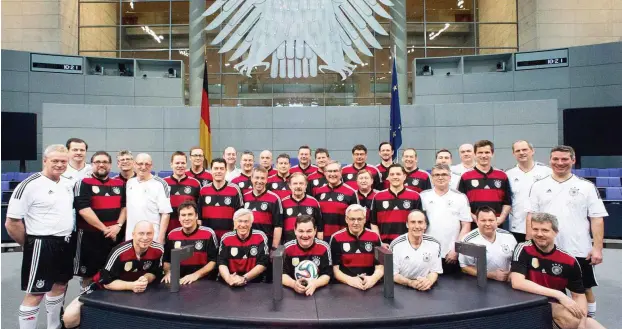  ?? Fotos: Studio Kohlmeier ?? Der FC Bundestag, hier aufgereiht im Plenarsaal, bei einem Fototermin mit DFB-Präsident Grindel. Am Ball sitzt Mannschaft­skapitän Marcus Weinberg aus Hamburg (CDU).