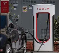  ?? (Bloomberg/David Paul Morris) ?? A Tesla vehicle charges at a Tesla Supercharg­er station at San Mateo, Calif., in late September.