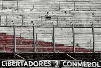  ?? Alejandro Pagni/AFP ?? Torcedor do River Plate aguarda o jogo que não aconteceu no Monumental
