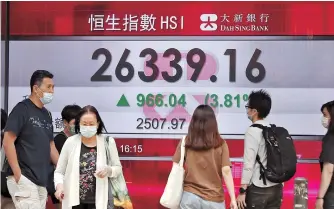  ??  ?? People walk past a stock quotation board showing the Hang Seng Index in
Hong Kong yesterday. The benchmark Hang Seng Index surged 3.81 percent, or 966.04 points, to 26,339.16 points yesterday. The turnover rose to HK$250 billion (US$32.25 billion), marking a new high in more than two years and showing strong momentum of the market. — Xinhua