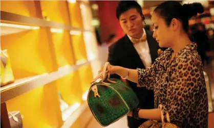  ?? Photograph: Carlos Barria/Reuters ?? A woman shops in a Louis Vuitton store in downtown Shanghai.