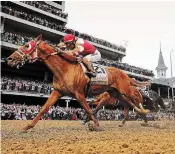  ?? ROB CARR GETTY IMAGES ?? Sonny Leon rides Rich Strike over the finish line to win the Kentucky Derby on Saturday.