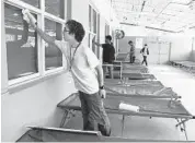  ?? CARLINE JEAN/STAFF PHOTOGRAPH­ER ?? Eric Vendrell,17, of Pembroke Pines cleans windows at the Salvation Army in Fort Lauderdale during summer camp.