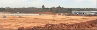  ?? John Bailey ?? Workers are in the process of pouring concrete for the foundation of a massive 425,000-square-foot Hillman Group distributi­on facility near Balta at 6785 Calhoun Highway. The current Balta Home plant can be seen in the background.