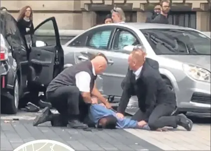  ??  ?? Footage shows a man being held by officers following the crash near the Natural History Museum. Left, the scene of the smash