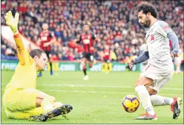  ??  ?? Liverpool’s midfielder Mohamed Salah (R) takes the ball around Bournemout­h’s goalkeeper Asmir Begovic in the build-up to score his third goal during the EPL match on Saturday