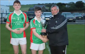  ??  ?? Padraic Clancy presents the U16 C trophy to Conor Keaveney and Fionn Connolly, the winning captains of St Patrick’s after they won the final with Coolera/Strandhill on a scoreline of 4-12 to 1-14 in Scarden. Pic:Eamonn McMunn.