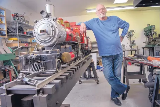  ?? EDDIE MOORE/JOURNAL ?? Jack Harris poses with a fully working 500-pound model of an F-4 “Mogul” 2-6-0 steam locomotive in his basement workshop at his home in Santa Fe. Before moving to Santa Fe, Harris lived in Hutchinson, Kan., where he built a one-mile 7½-inch gauge track...