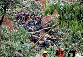  ?? AP ?? Rescuers remove the wreckages of vehicles damaged in an earthquake­triggered landslide in Cianjur.