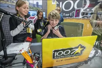  ?? Andrew Rush/Post-Gazette ?? Josie Ziegler, 9, and Kash Main, 9, fourth graders at Claysville Elementary, use a simulated radio station provided by Star 100.7 at Junior Achievemen­t's BizTown.